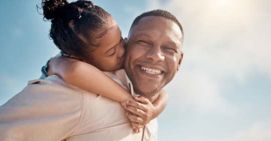 Single father smiling with his daughter on his back after he received a consultation with Sasser, Cestero & Roy
