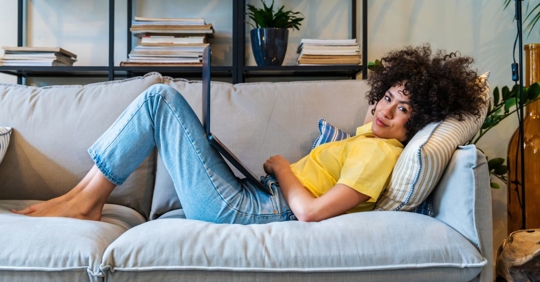Woman laying down on a couch pondering getting divorced